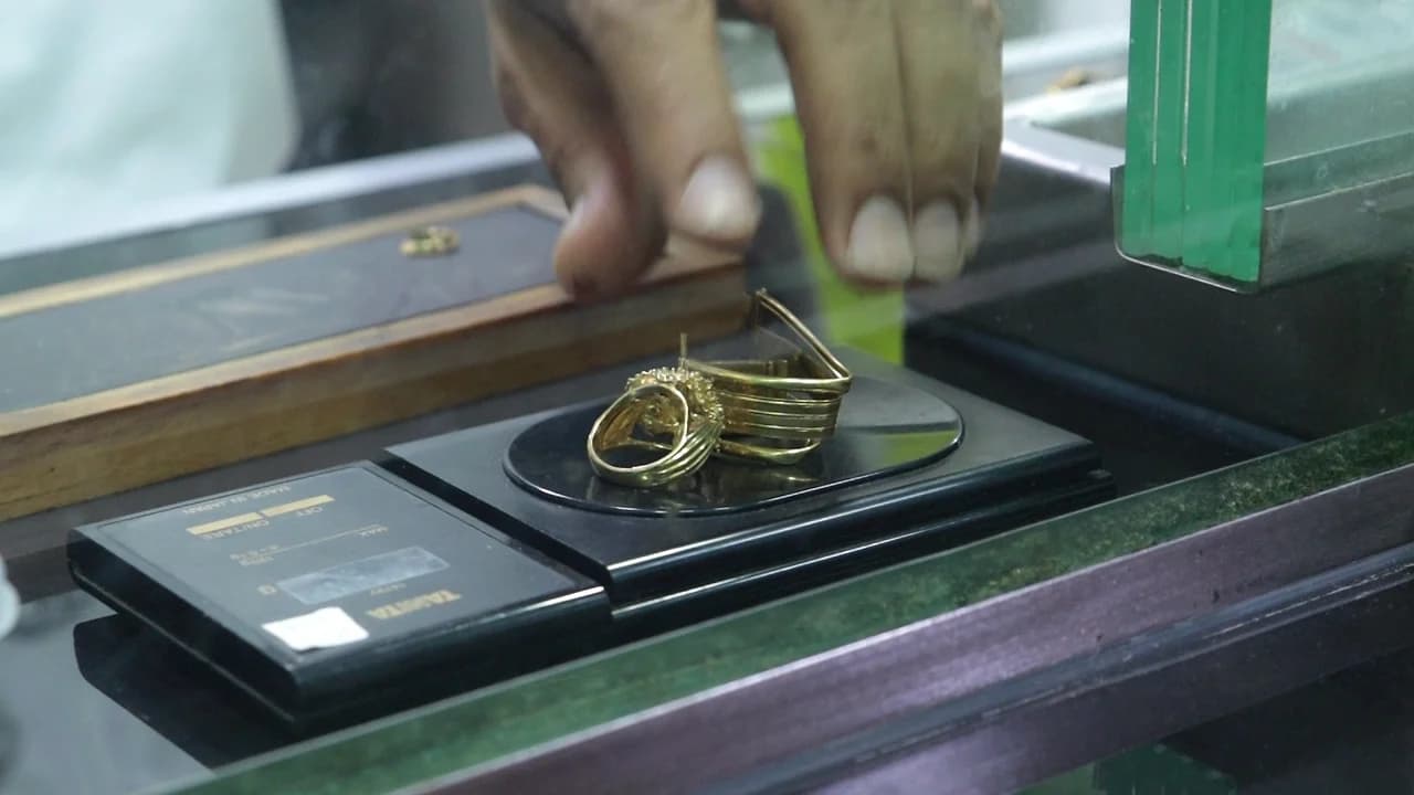 Anillos y argollas de oro en desuso sobre la balanza, en la ventanilla